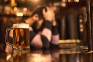 Depressed man drinking beer at the bar